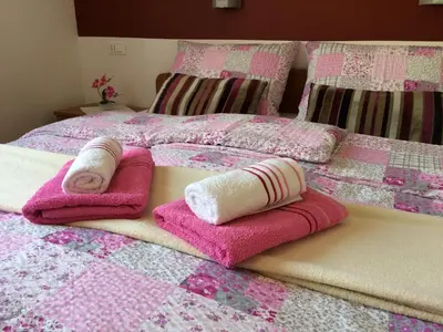a bed with pink and white towels on it at Apartments and Rooms Tavcar in Bled