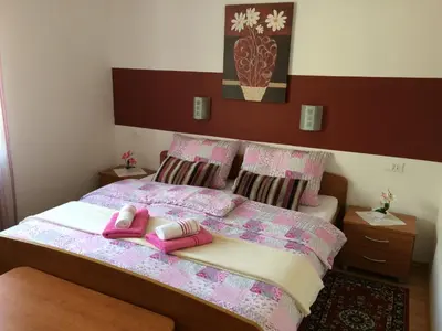 a bedroom with a bed with two pink slippers on it at Apartments and Rooms Tavcar in Bled