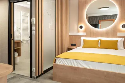 a bedroom with a bed and a mirror at Hotel MANTOVA Vrhnika in Vrhnika