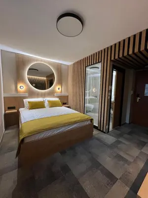 a bedroom with a large bed and a mirror at Hotel MANTOVA Vrhnika in Vrhnika