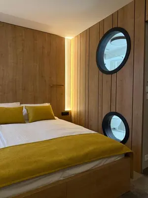 a bedroom with a bed with two round windows at Hotel MANTOVA Vrhnika in Vrhnika
