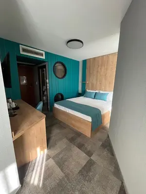 a bedroom with a bed and blue walls at Hotel MANTOVA Vrhnika in Vrhnika
