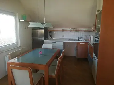 a kitchen with a table and chairs and a sink at Peaceful 4-room house in Maribor - ski friendly in Maribor
