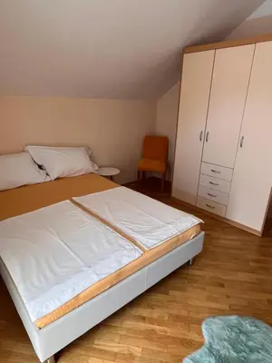 a bedroom with a bed and a cabinet and a chair at Peaceful 4-room house in Maribor - ski friendly in Maribor