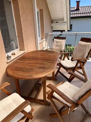 a wooden table and chairs on a balcony at Peaceful 4-room house in Maribor - ski friendly in Maribor