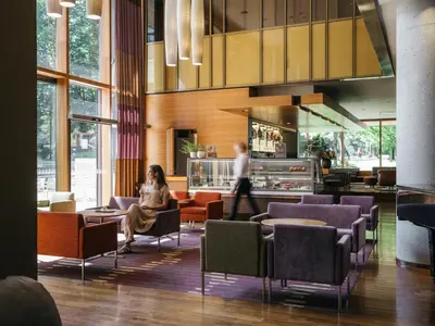 a lobby with people sitting in chairs and tables at Hotel Balnea Superior - Terme Krka in Dolenjske Toplice