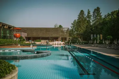 a large swimming pool with blue water in front of a building at Hotel Balnea Superior - Terme Krka in Dolenjske Toplice