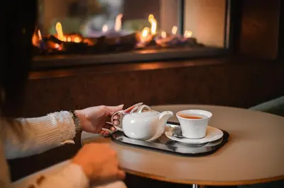 a person holding a cup of coffee on a table at Hotel Balnea Superior - Terme Krka in Dolenjske Toplice