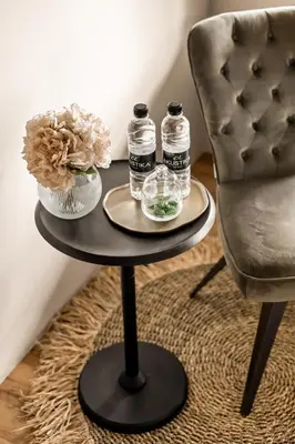 a table with two bottles on it next to a chair at Harmonija Padel&Wellness Resort in Mengeš