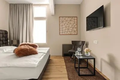 a bedroom with a bed with a teddy bear on it at Harmonija Padel&Wellness Resort in Mengeš