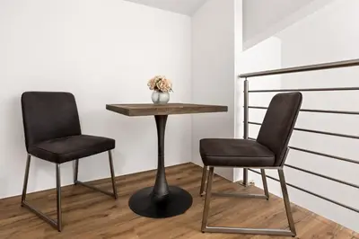 two chairs and a table in a room at Harmonija Padel&Wellness Resort in Mengeš