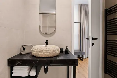 a bathroom with a sink and a mirror at Harmonija Padel&Wellness Resort in Mengeš