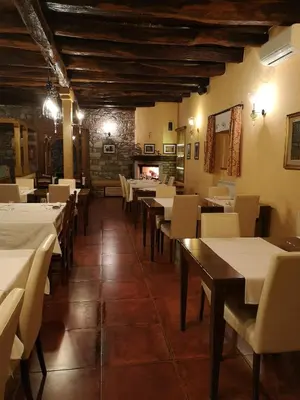 a restaurant with tables and chairs and a fireplace at Domačija Linč in Rodik