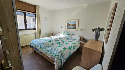 a bedroom with a bed and a vase on a table at Apartment Panorama & Bella Vista in Bohinjska Bela