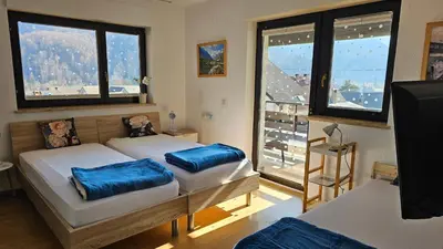 a bedroom with two beds with blue pillows on them at Apartment Panorama & Bella Vista in Bohinjska Bela