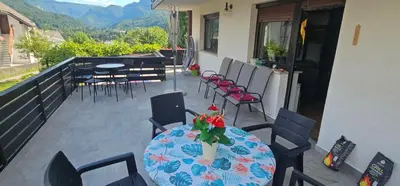 a patio with a table and chairs on a balcony at Apartment Panorama & Bella Vista in Bohinjska Bela