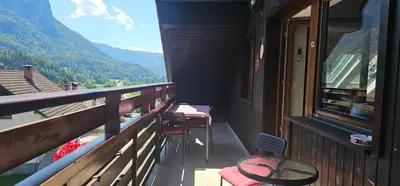 a balcony with tables and chairs and a view of mountains at Apartment Panorama & Bella Vista in Bohinjska Bela