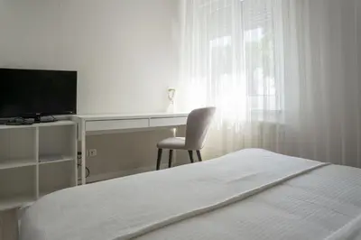 a bedroom with a bed and a desk with a television at Hotel MOREA in Ljubljana