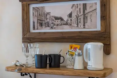 a shelf with coffee cups and a picture of a street at Pension Lectar in Radovljica