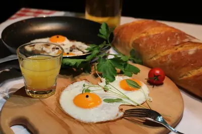 a plate of eggs and bread and a glass of orange juice at Pension Lectar in Radovljica