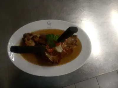 a bowl of soup with meat and vegetables on a table at Gostilna Tratnik in Zoll