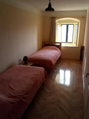 two beds in a room with a window at Gostilna Tratnik in Zoll