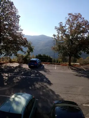 a car parked in a parking lot with mountains in the background at Gostilna Tratnik in Zoll