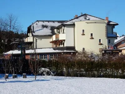 a large building in the snow in front at Garni Hotel & Apartments Terano in Maribor