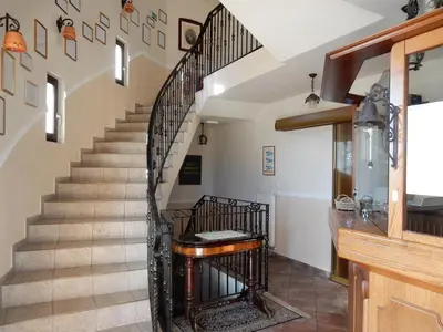 a spiral staircase with a wooden stair case at Garni Hotel & Apartments Terano in Maribor