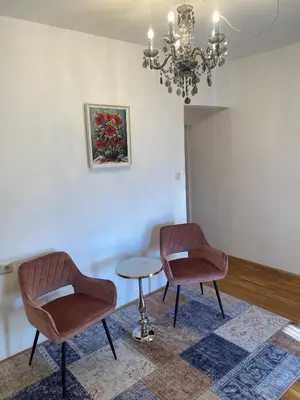 two chairs and a table in a room with a chandelier at Kunstelj Pension in Radovljica
