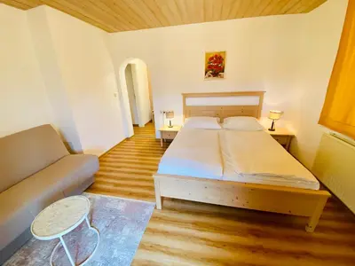 a small bedroom with a bed and a couch at Kunstelj Pension in Radovljica