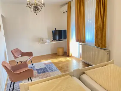 a living room with a couch and chairs and a tv at Kunstelj Pension in Radovljica