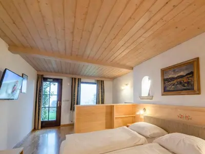 a bedroom with a large bed with a wooden ceiling at Kunstelj Pension in Radovljica