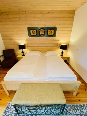a large bed in a room with two lamps at Kunstelj Pension in Radovljica