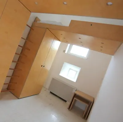 a room with a ceiling with a window and a stool at Hostel Celica in Ljubljana