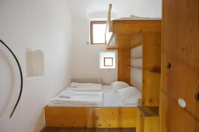 a small room with two bunk beds and a ladder at Hostel Celica in Ljubljana