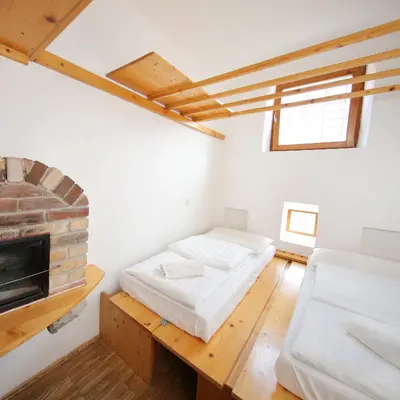 a bedroom with two beds and a fireplace at Hostel Celica in Ljubljana