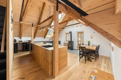 an open kitchen and dining room with wooden beams at Hiša na soncu / Sun house in Zgornje Gorje