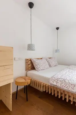 two beds in a room with two pendant lights at Hiša na soncu / Sun house in Zgornje Gorje