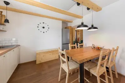 a kitchen and dining room with a wooden table and chairs at Hiša na soncu / Sun house in Zgornje Gorje