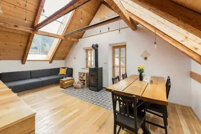 a living room with a table and a couch at Hiša na soncu / Sun house in Zgornje Gorje