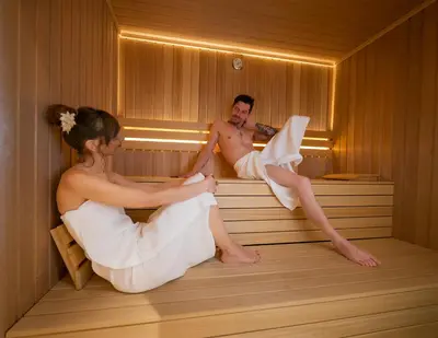 a bride and groom sitting in a sauna at Domačija Šeruga Countryside hotel in Novo Mesto