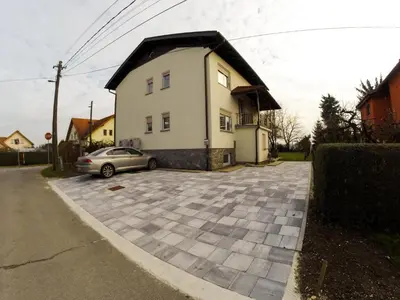 a house with a car parked in a parking lot at Apartments Andrej - Poetovio & Ptuj in Ptuj