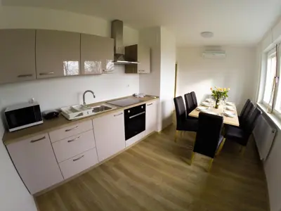 a kitchen and dining room with a table and chairs at Apartments Andrej - Poetovio & Ptuj in Ptuj