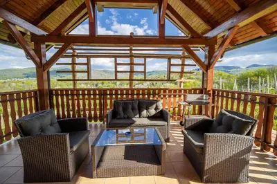 a screened in porch with two couches and a table at Holiday Home Blue Sky in Globocice