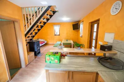 a kitchen with orange walls and a spiral staircase at Holiday Home Blue Sky in Globocice