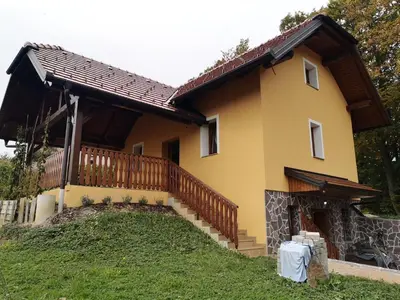 a large yellow house with a wooden staircase at Holiday Home Blue Sky in Globocice