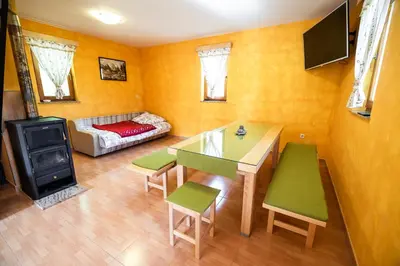 a living room with a table and chairs and a stove at Holiday Home Blue Sky in Globocice