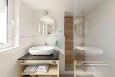 a white bathroom with a sink and a mirror at Ražman Wine Rooms in Gračišče