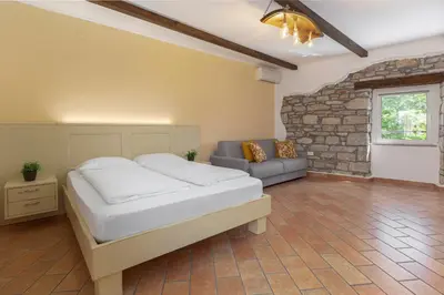 a bedroom with a bed and a couch at Ražman Wine Rooms in Gračišče
